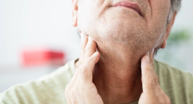 Man with throat cancer feeling his neck